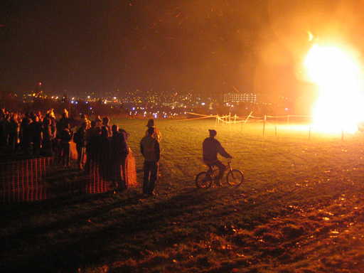 Onlookers watch a bonfire