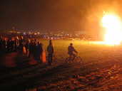 Onlookers watch a bonfire